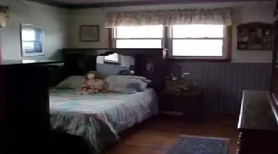 Masterbedroom with hardwood floors & a bathroom.