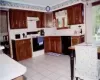 Kitchen has new ceramic tile, countertop w/built in cutting board, and new sink.