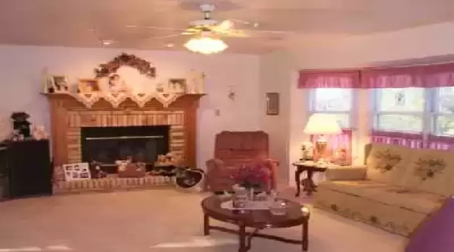 Family room with fireplace and bay window looks out onto back yard.