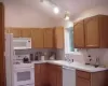 Oak kitchen with vaulted ceiling,skylight and view of woods out back. Neutral decor.