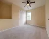 This bright and airy bedroom features a ceiling fa